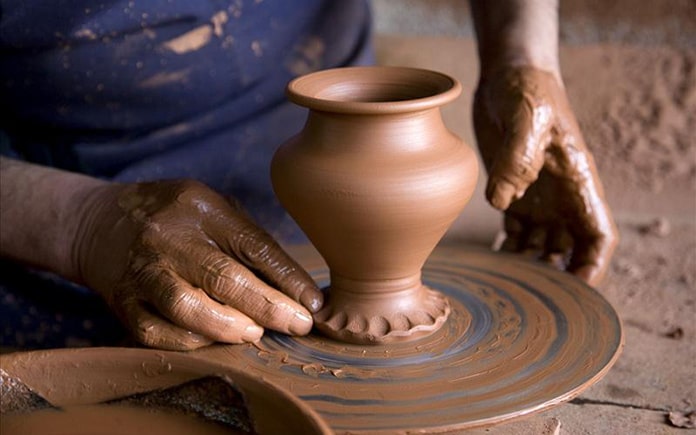 Artesano alfarero. Artesano de la alfarería en el torno con arcilla.